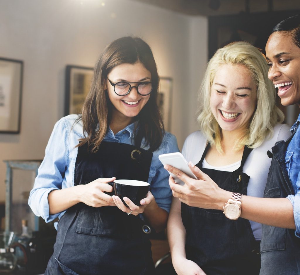 three employees read a message on a mobile device