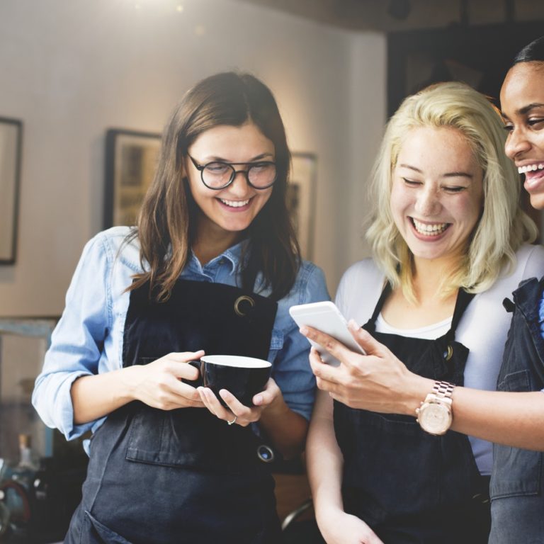 three employees read a message on a mobile device