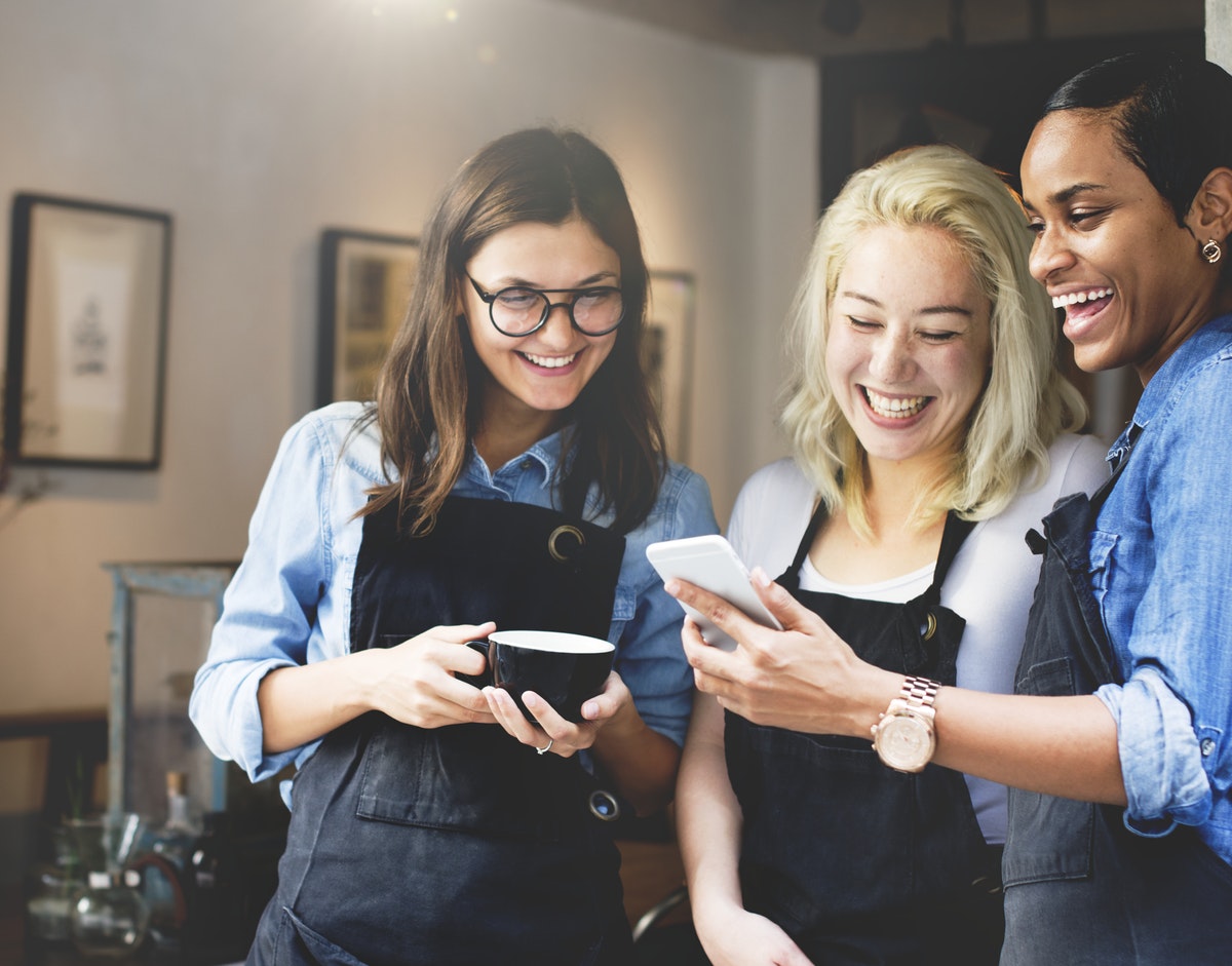 three employees read a message on a mobile device