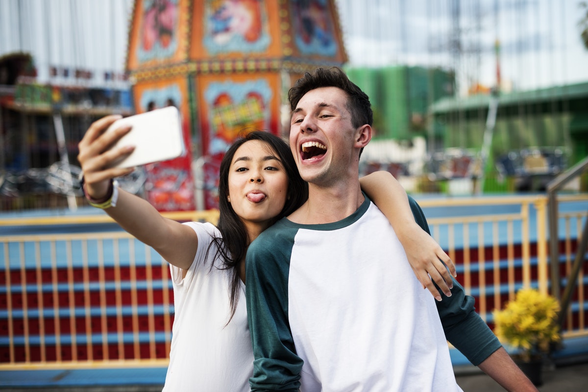 Two Gen Z individuals take a selfie with a smartphone